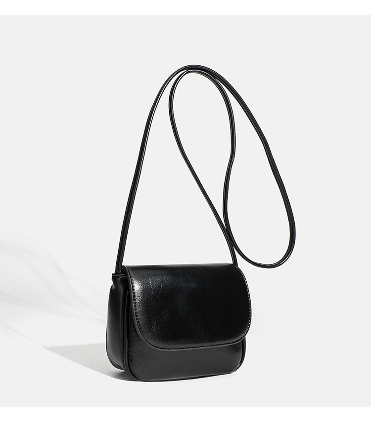Compact rounded rectangular flap crossbody bag with glossy leather-look finish and long shoulder strap, detail view 19