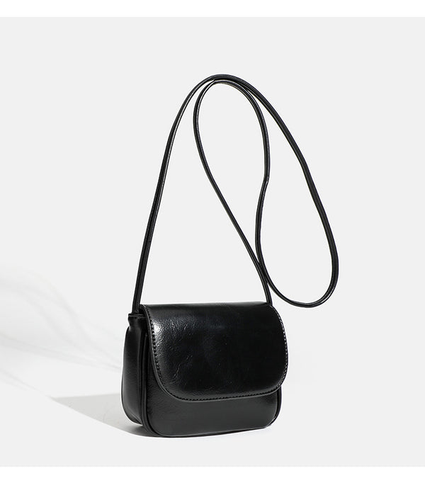 Compact rounded rectangular flap crossbody bag with glossy leather-look finish and long shoulder strap, detail view 19