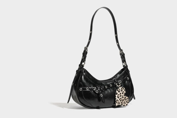 Kompakte, sichelförmige Schultertasche in glänzender bordeauxroter Lederoptik mit silberfarbenem Ösenschnallenriemen und Leopardenmuster