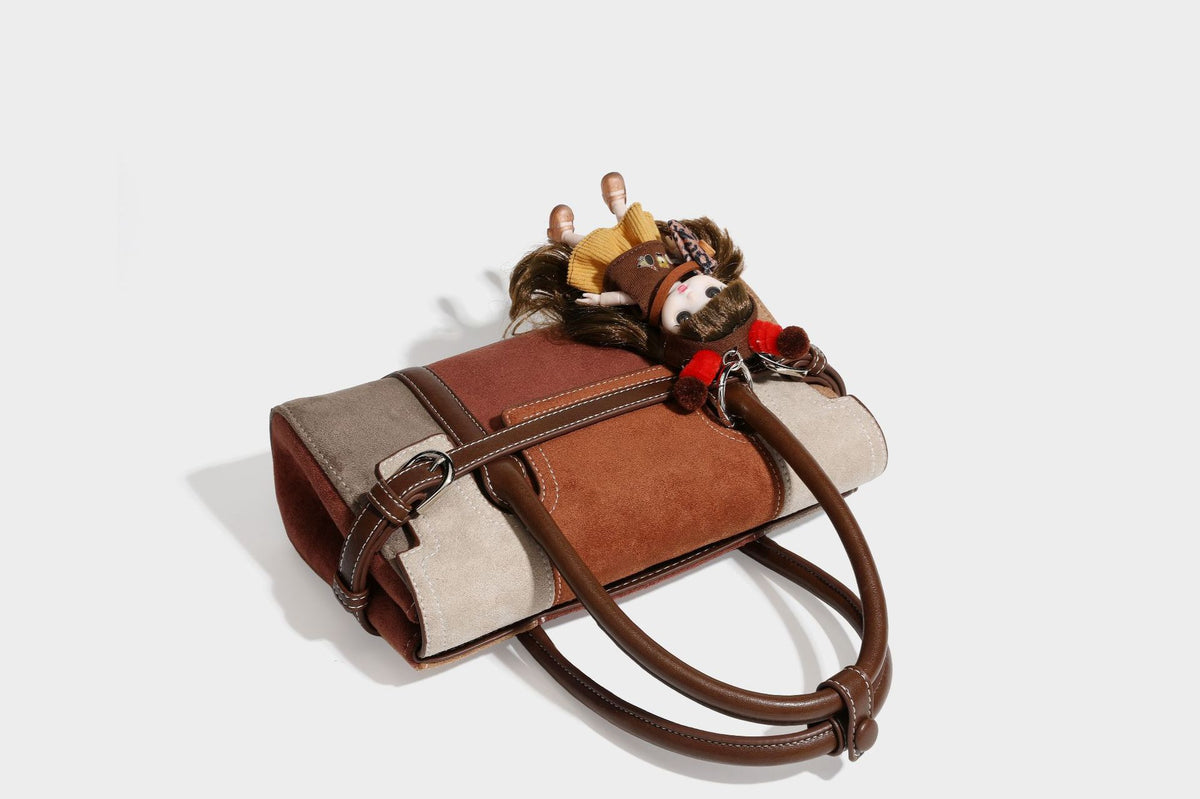 Structured color-block satchel bag in brown, rust, beige, and taupe suede-look panels with white topstitching, front buckle