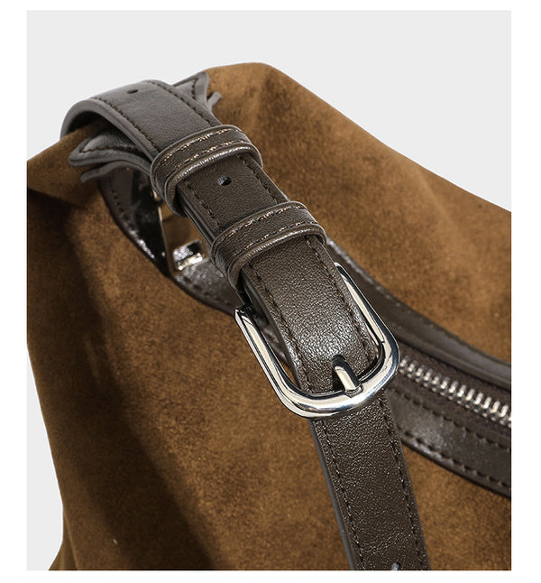 Lässige Hobo-Schultertasche mit matter brauner Wildlederoptik, dunklen glatten Besätzen, Reißverschluss oben und langem, verstellbarem