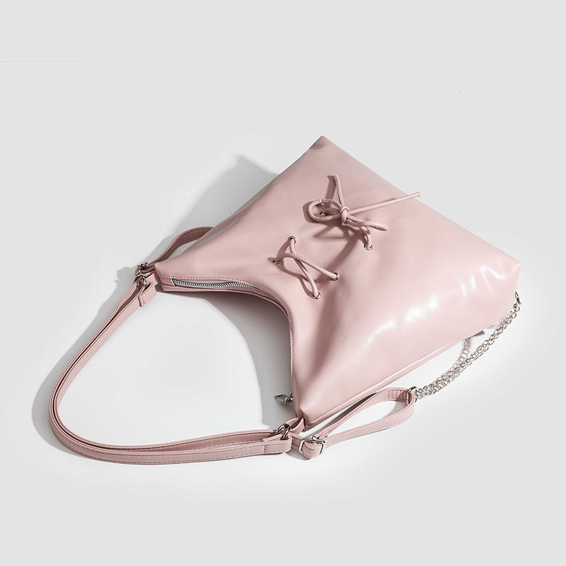 Glossy leather-look hobo shoulder bag with front bow lacing detail and silver-tone chain strap, detail view 4