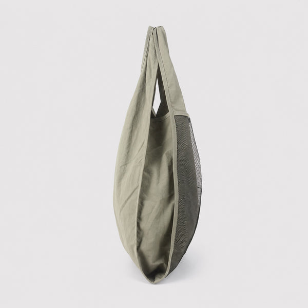 Oversized triangular mesh tote bag with matte olive-khaki fabric straps and trim, dark open-weave mesh body, matte black