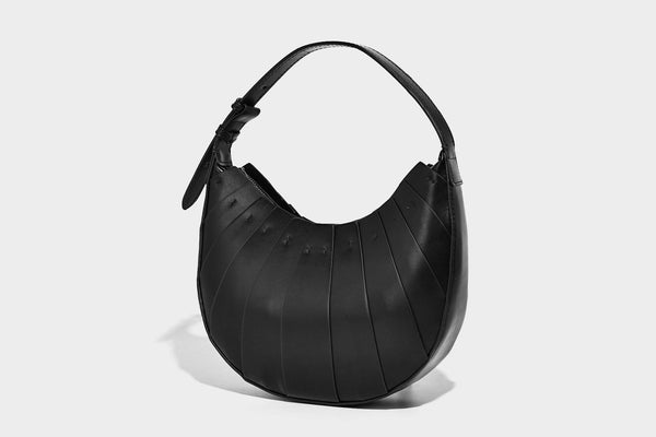 Crescent half-moon shoulder bag with vertical panel seaming, matte-satin leather-look finish, and adjustable gold-tone