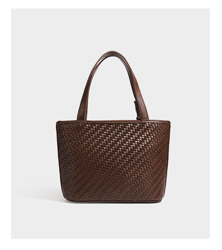 Strukturierte Tote Bag mit gewebter Oberfläche in Braun, goldfarbenen Metalldetails, seilumwickelten Tragegriffen, einer kleinen Fronttasche und weiteren Details