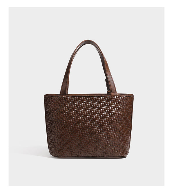 Strukturierte Tote Bag mit gewebter Oberfläche in Braun, goldfarbenen Metalldetails, seilumwickelten Tragegriffen, einer kleinen Fronttasche und weiteren Details