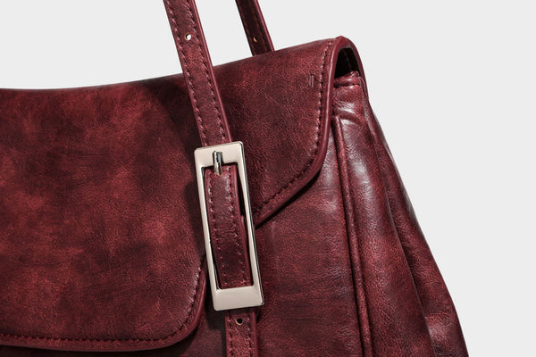 Structured flap-top shoulder tote bag in distressed leather-look finish with silver-tone buckle hardware and double shoulder