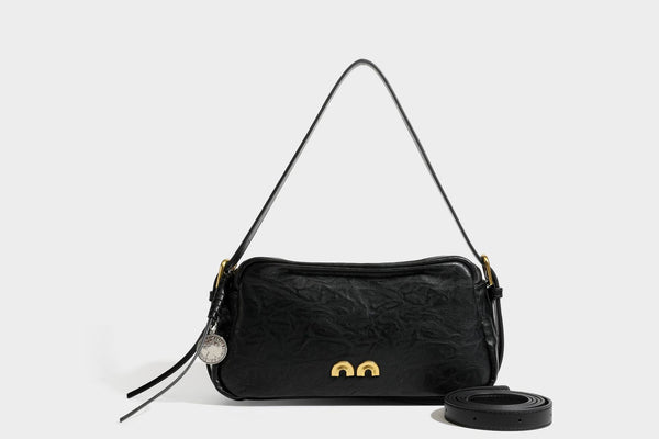 Compact black crinkled leather-look baguette shoulder bag with gold-tone arch hardware and adjustable strap, detail view 24