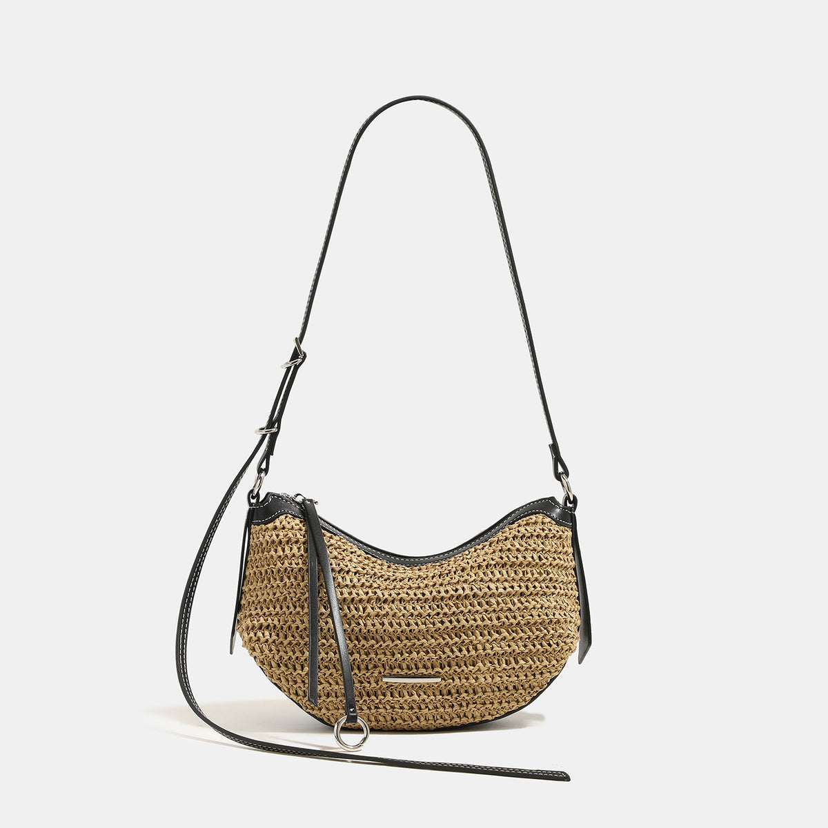 Compact crescent-shaped woven straw crossbody bag with black leather-look trim, top zip closure, and adjustable shoulder
