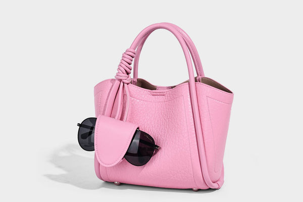 Structured mini tote bag in pebbled leather-look finish with knotted top handles, front flap pocket, and detachable shoulder