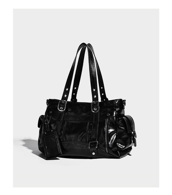 Glossy structured black tote shoulder bag with silver buckle hardware, zip pockets, dual top handles, and detachable, detail