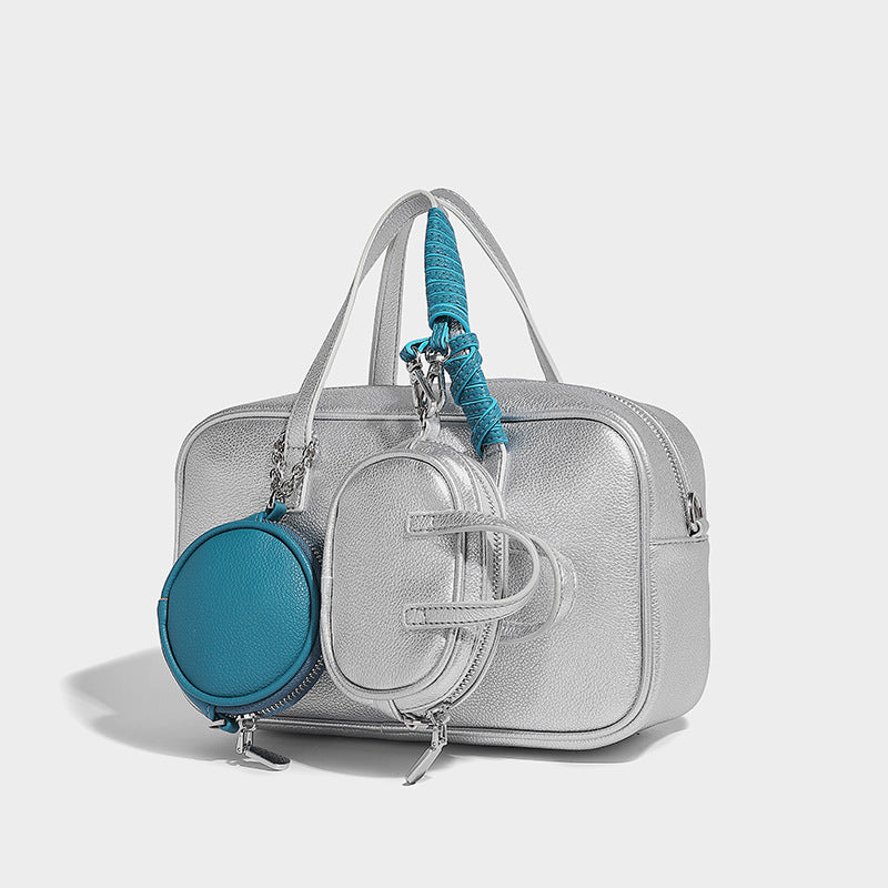 Structured pebbled leather-look Boston bowling bag in tan with blue detachable round mini pouch, dual top handles, and