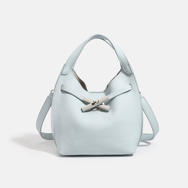 Compact pebbled leather-look shoulder bag with crossed silver-toned metal front closure, short top handle, and long, detail