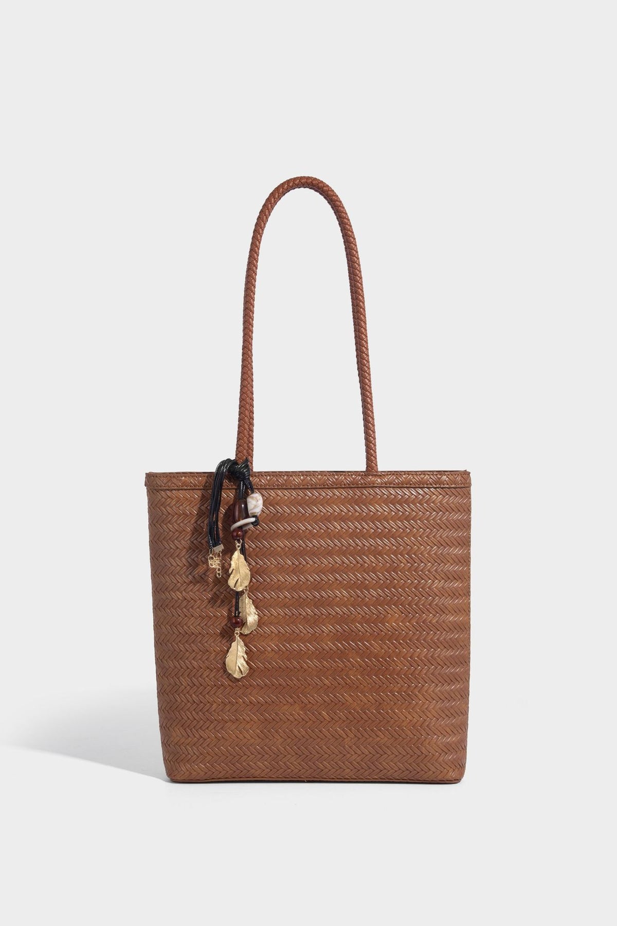 Structured woven herringbone tote bag with braided double shoulder handles in tan brown, shown with matching drawstring