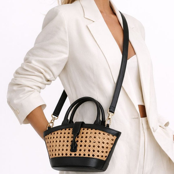 Structured mini tote bag with open-weave rattan body, leather-look arched handles and trim, front tab turn-lock closure, and