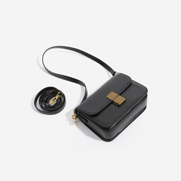Mini structured black flap crossbody bag with gold-tone ribbed rectangular clasp and adjustable shoulder strap, detail view 4
