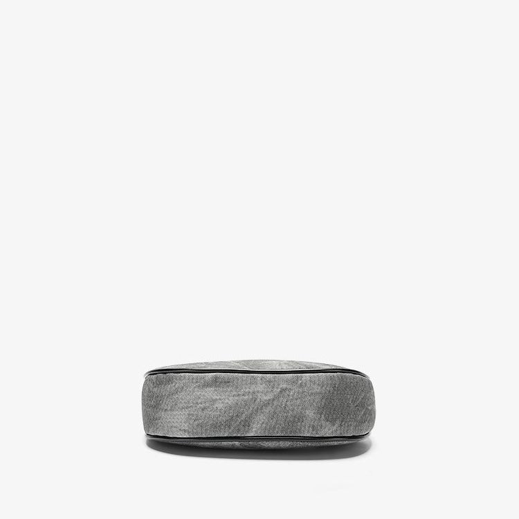 Small gray crescent half-moon shoulder bag with black leather-look trim, gold-tone zipper, and adjustable slim strap, detail