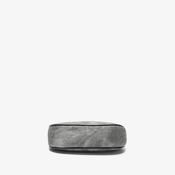 Small gray crescent half-moon shoulder bag with black leather-look trim, gold-tone zipper, and adjustable slim strap, detail