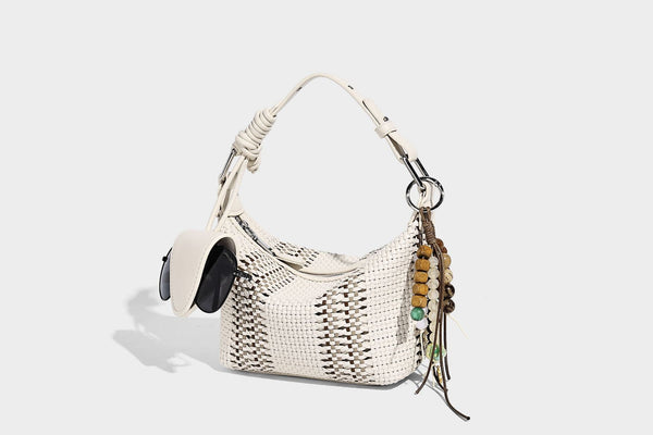Small woven crescent shoulder bag with leather-look trim, zip closure, silver-tone ring hardware, and beaded tassel charm