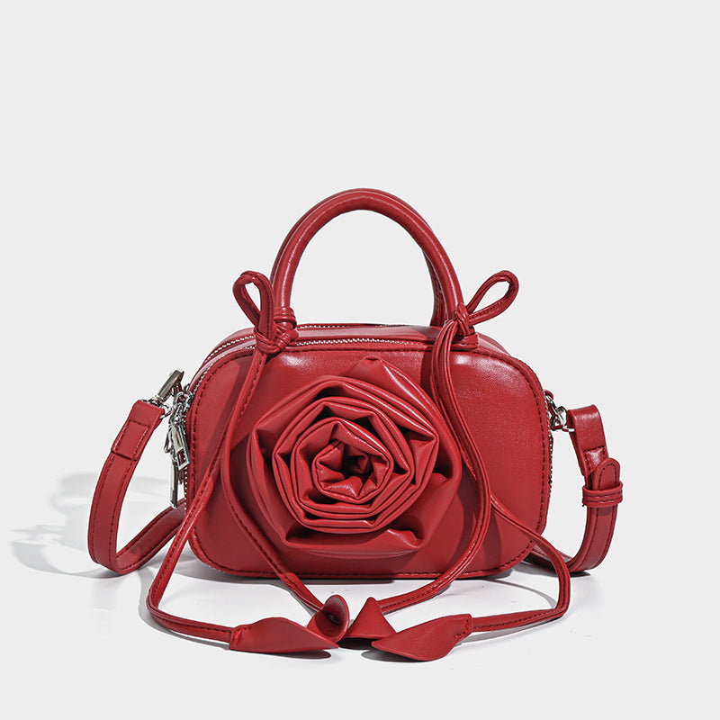 compact barrel bag with 3D rose appliqué, dual zip top, knotted handle, and adjustable crossbody strap, detail view 6