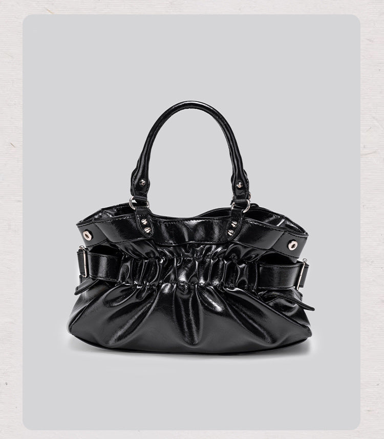 Black glossy ruched convertible tote bag with silver-tone rivets, detachable wide shoulder strap, external zip pouch, and