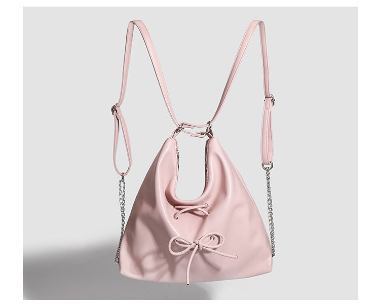 Glossy leather-look hobo shoulder bag with front bow lacing detail and silver-tone chain strap, detail view 18