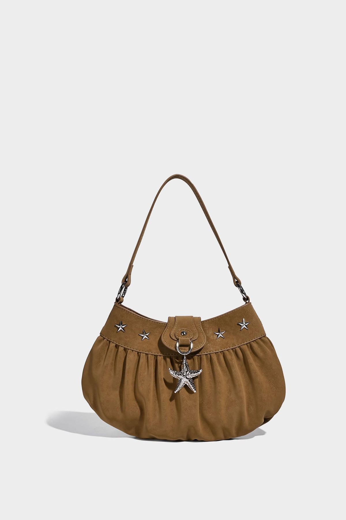Ruched shoulder bag with curved flap, silver star studs, dangling starfish charm, and adjustable crossbody strap, detail view