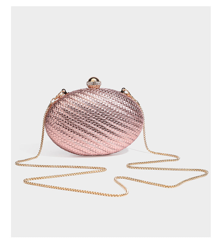 Kleine ovale Clutch aus metallisch glänzendem Flechtmaterial mit juwelenbesetztem Bügelverschluss in Goldoptik und abnehmbarem Kettenriemen, Detailansicht 8