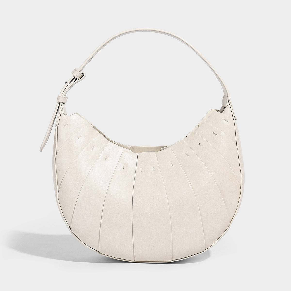 Crescent half-moon shoulder bag with vertical panel seaming, matte-satin leather-look finish, and adjustable gold-tone