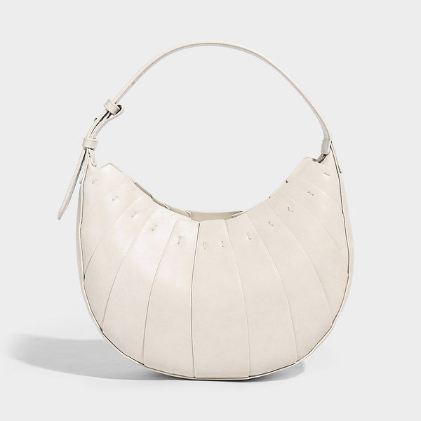 Crescent half-moon shoulder bag with vertical panel seaming, matte-satin leather-look finish, and adjustable gold-tone