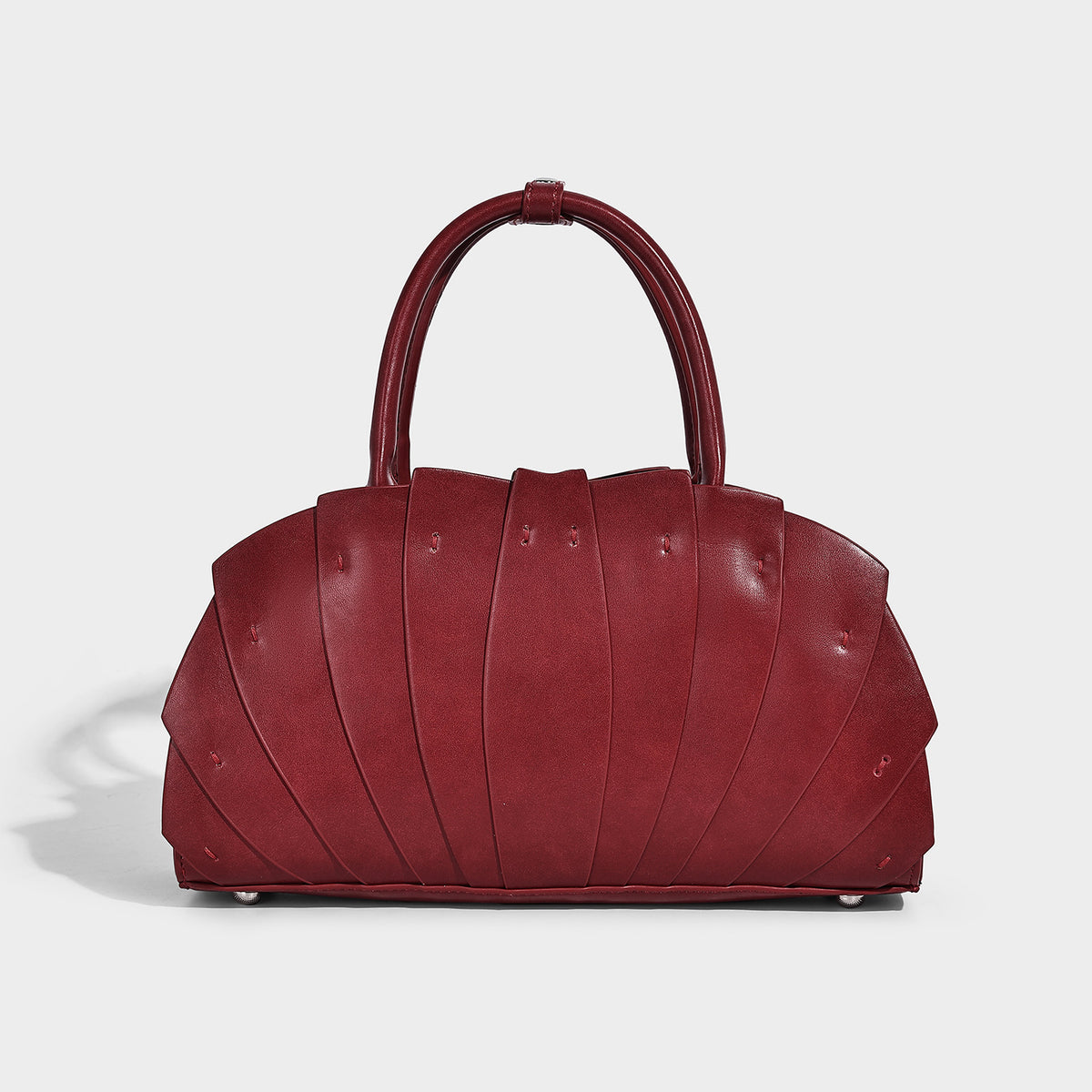 Structured dome satchel with fan-pleated leather-look exterior, dual top handles, and detachable shoulder strap, detail view