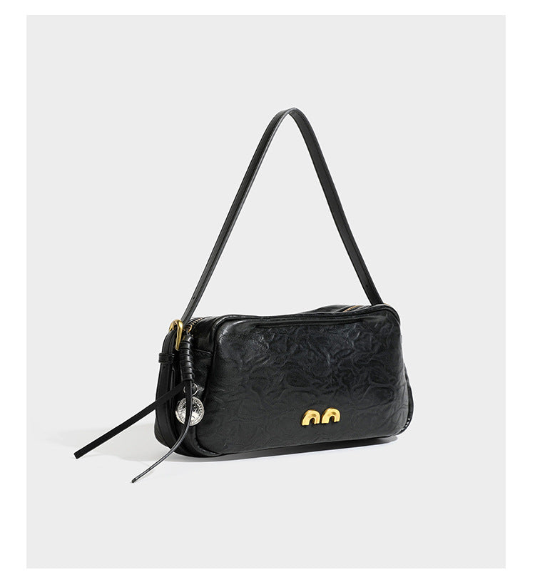 Compact black crinkled leather-look baguette shoulder bag with gold-tone arch hardware and adjustable strap, detail view 8