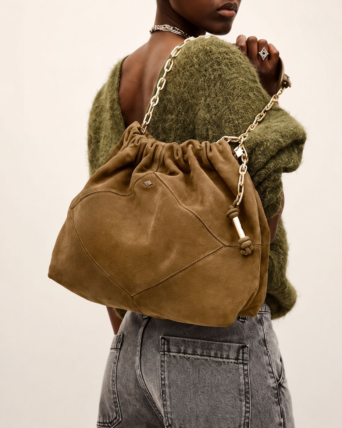 Slouchy suede-look shoulder bag with gathered top, angular stitched paneling, and chunky gold-tone chain strap, detail view