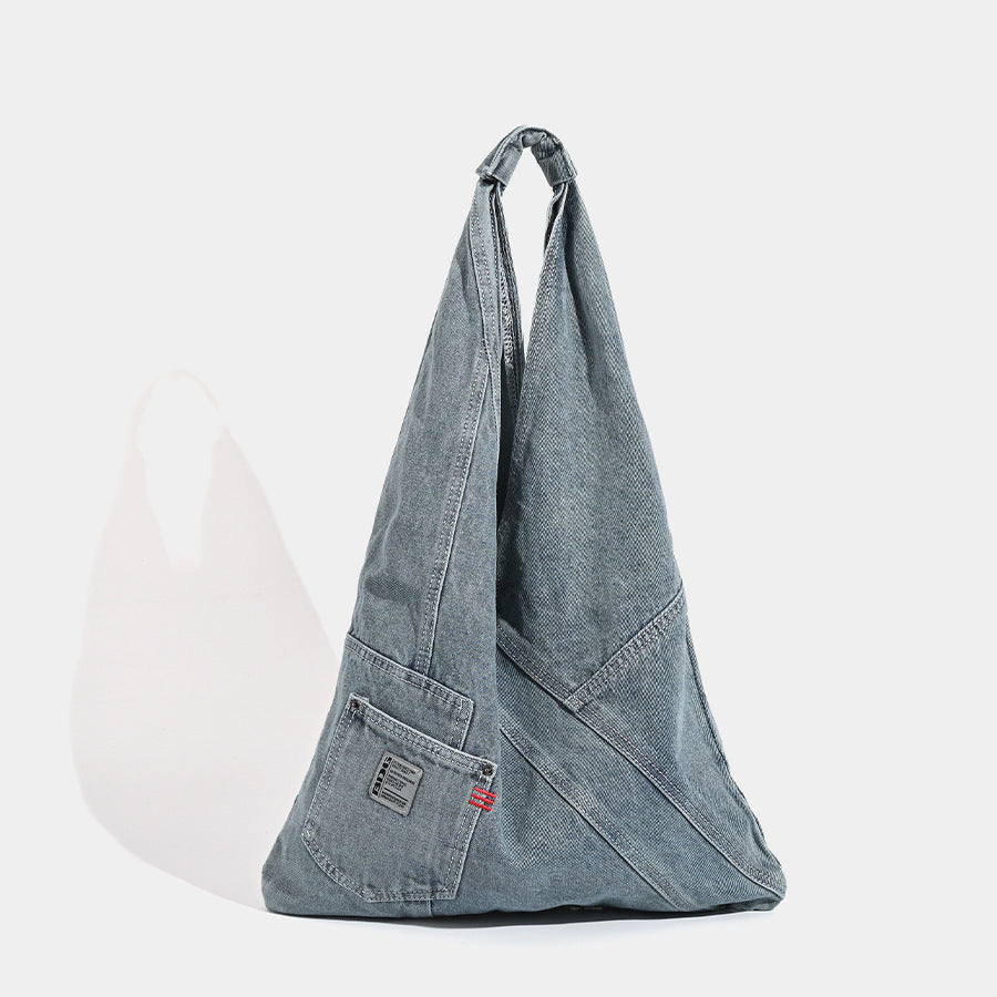 Washed denim slouch tote bag with patch pocket and contrast stitching, front view