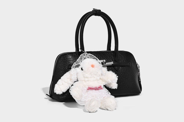 Small structured shell-silhouette top-handle bag with pebbled leather-look finish, silver-tone turn-lock hardware, and