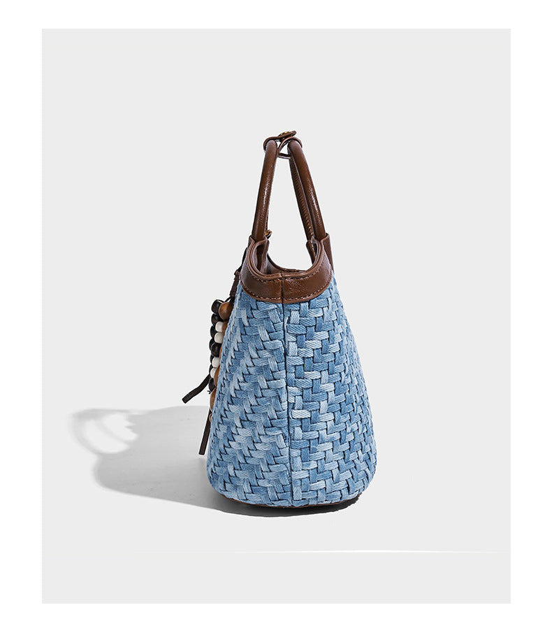 Blaue gewebte Beuteltasche in Denim-Optik mit brauner Besatz in Lederoptik, rundem Tragegriff, Quastenanhänger mit Holzperlen und verstellbarem