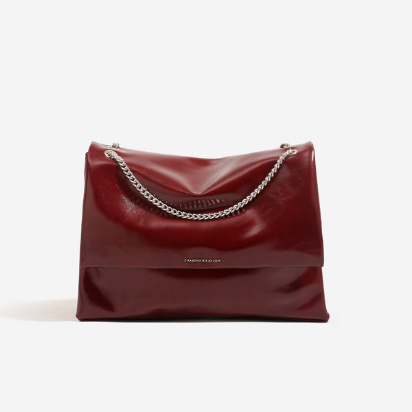 Große Schultertasche mit Überschlag aus glänzender Lederoptik, silberfarbenem Kettenriemen und magnetischem Druckverschluss, Detailansicht 8