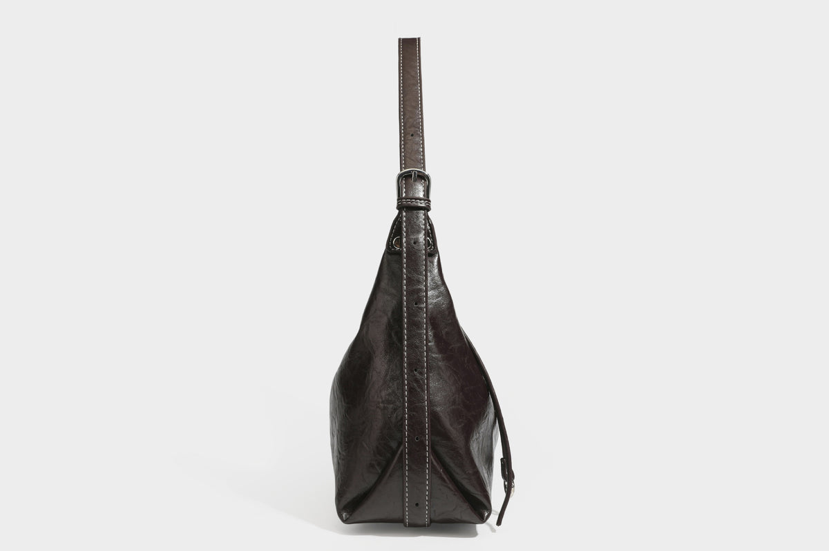 Slouchy hobo shoulder bag in glossy crinkled leather-look finish with zip-top closure and silver-tone ring hardware, detail