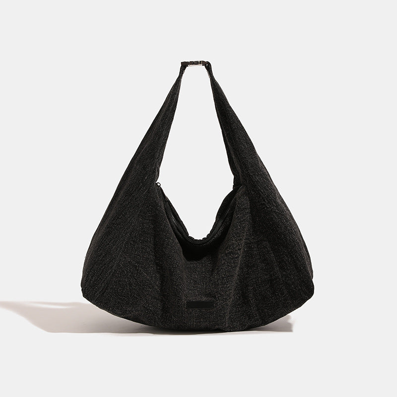Oversized slouchy hobo shoulder bag in dark marled denim-texture fabric with top zip closure and adjustable single strap