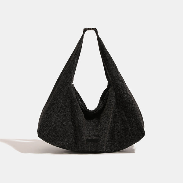 Oversized slouchy hobo shoulder bag in dark marled denim-texture fabric with top zip closure and adjustable single strap