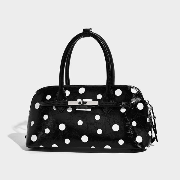 Glossy structured polka-dot satchel bag with dual top handles, silver turn-lock hardware, and detachable shoulder strap