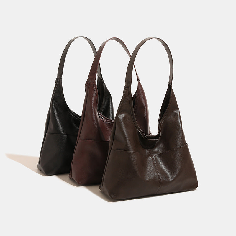 Oversize-Hobo-Shopper in Dunkelbraun mit glatter, matter Oberfläche in Lederoptik, langem flachem Schulterriemen und segmentiertem Design