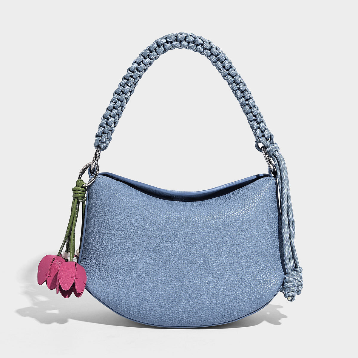Small crescent half-moon bag in pebbled leather-look finish with braided top handle, silver-tone ring hardware, and, detail