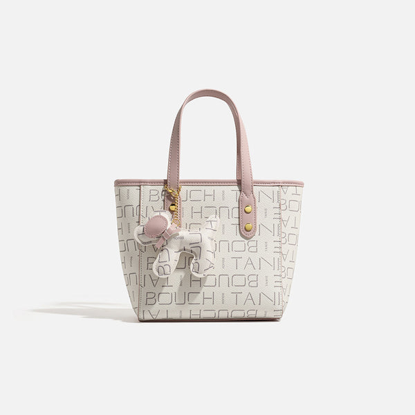 Kleine strukturierte Mini-Tote-Bag mit Logoprint, zartrosa Besatz, goldfarbenen Beschlägen, zwei oberen Henkeln und baumelndem Bärenanhänger
