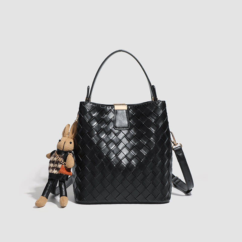 Black woven leather-look bucket bag with gold-tone clip closure, top handle, detachable shoulder strap, and knit bunny charm