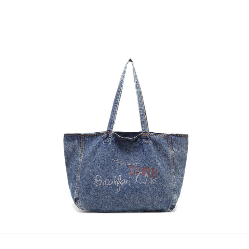 Große Tote Bag aus verwaschenem blauem Denim mit Grafikprint im handschriftlichen Stil, orangefarbenen Kontrastnähten und langem Stoffschulterriemen