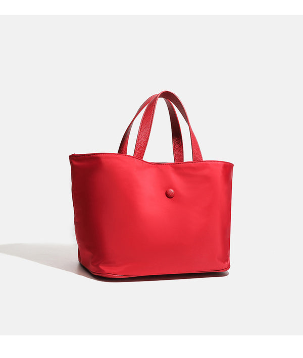 Structured lightweight nylon tote bag with textured double top handles and snap-button front detail, detail view 13