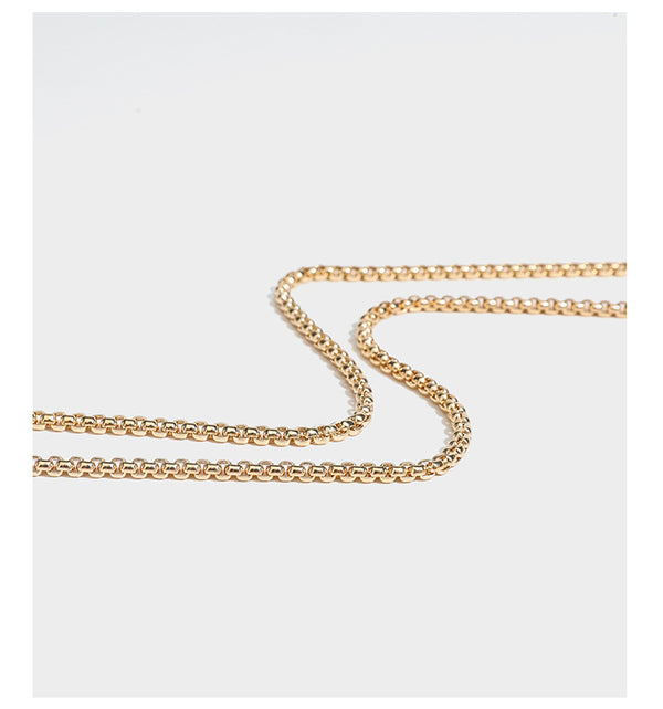 Small structured rectangular metallic woven-texture clutch bag with jeweled knob clasp and gold-tone chain strap, detail view