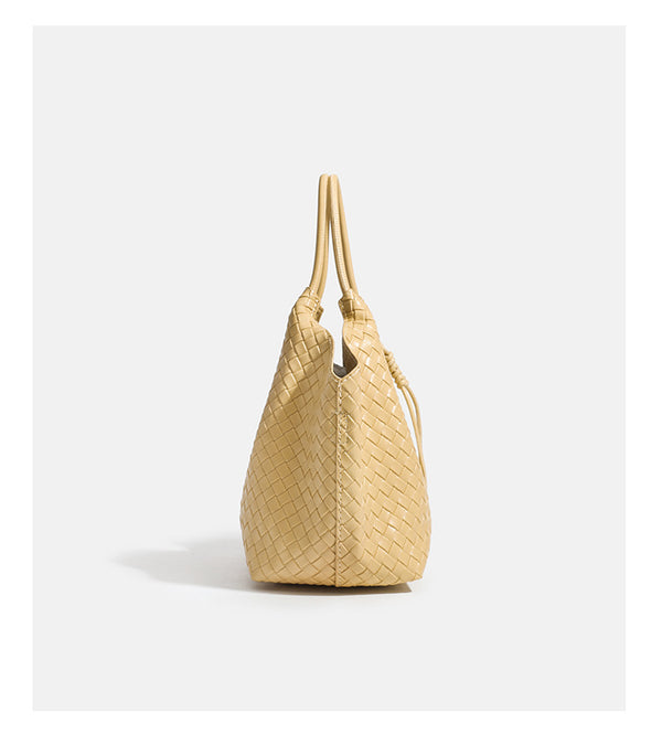 Weich strukturierte gewebte Tote-Bag in Gelbgold mit Lederoptik, V-förmiger offener Oberseite, seitlichen Kordeldetails und zwei röhrenförmigen
