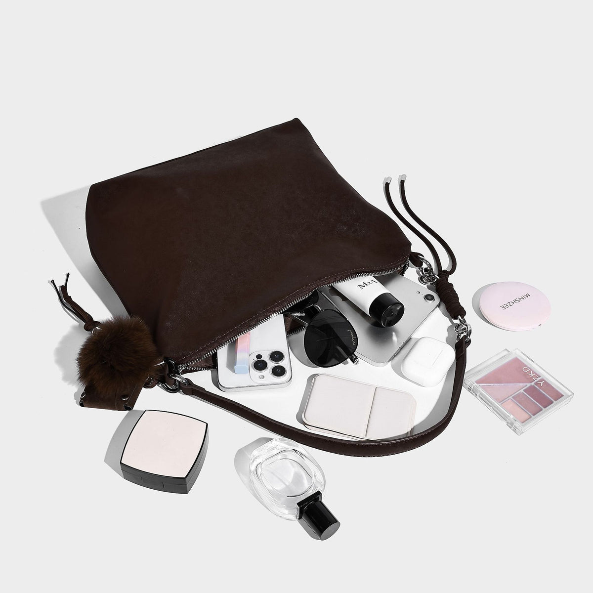 Slouchy matte-finish hobo shoulder bag with tassel cords, silver-tone hardware, and faux-fur pom charm, detail view 4
